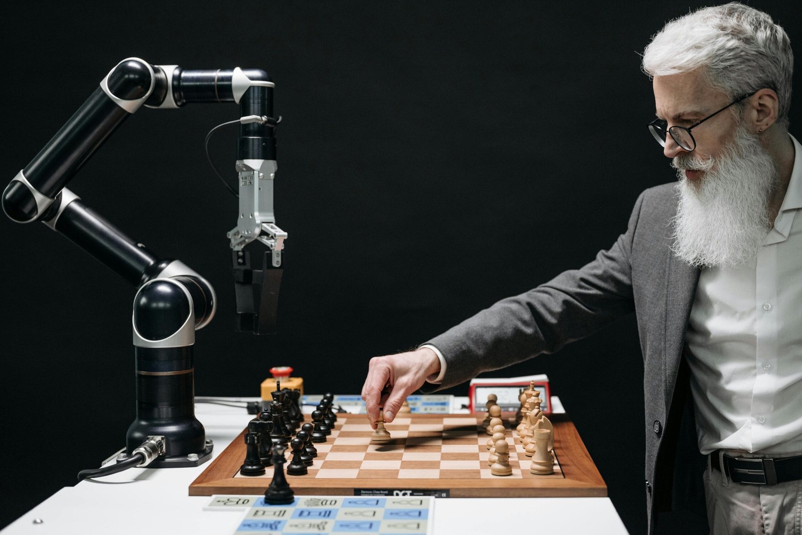 A bearded man strategically moves chess pieces while an AI robot arm assists in a futuristic game.